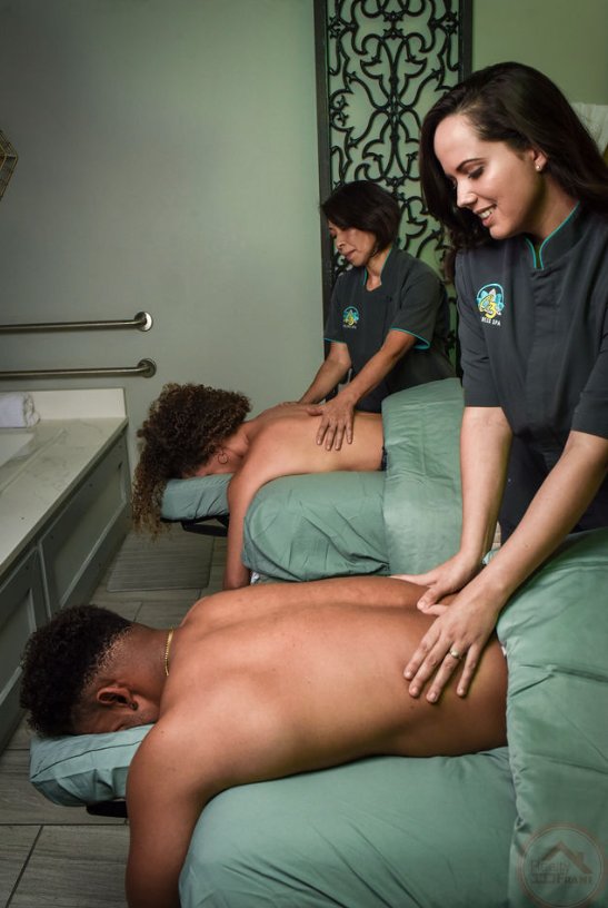 Two licensed massage therapists working on clients in a treatment room at C3 Wellness Spa in Raleigh