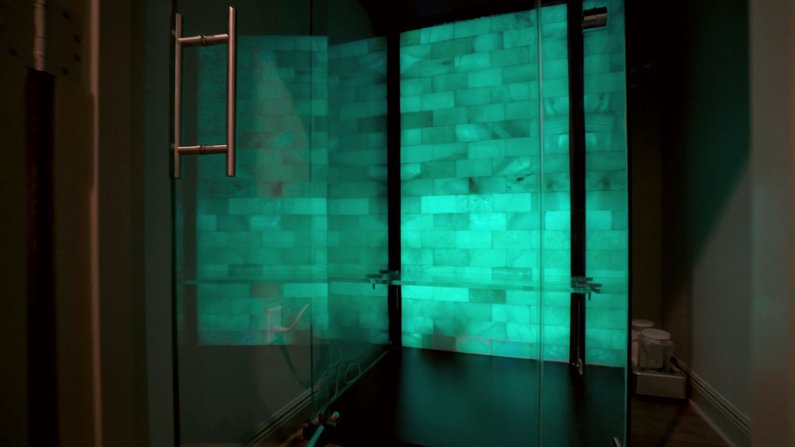 Glowing Himalayan salt wall behind glass at C3 Wellness Spa